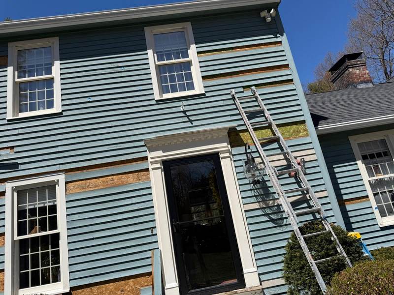 Blue house siding and window trim photographed during exterior work.