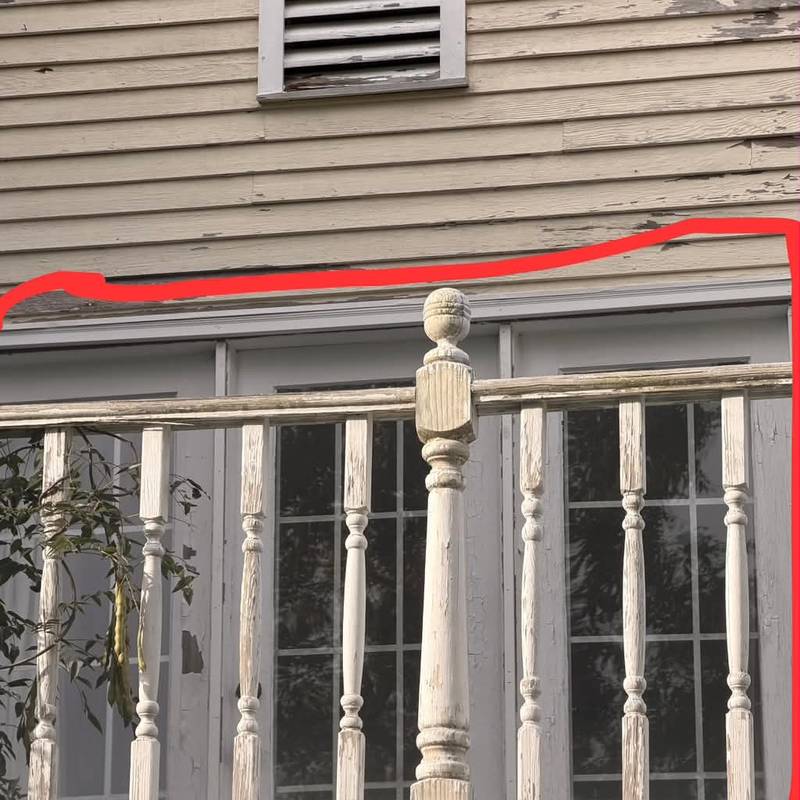 A porch railing and trim with the repair area outlined in red.