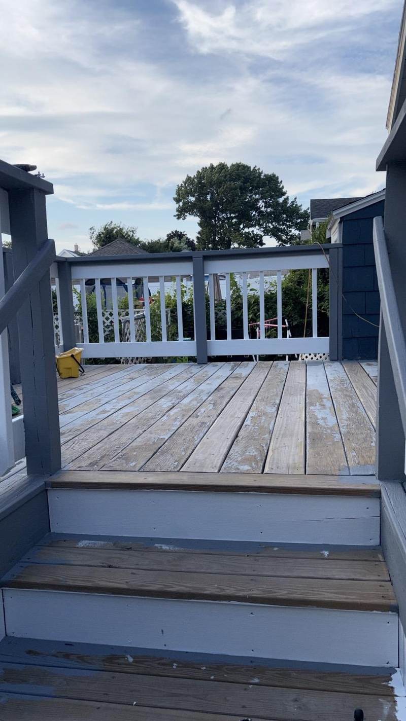 A back deck with a navy blue railing and white balusters, photographed on site.