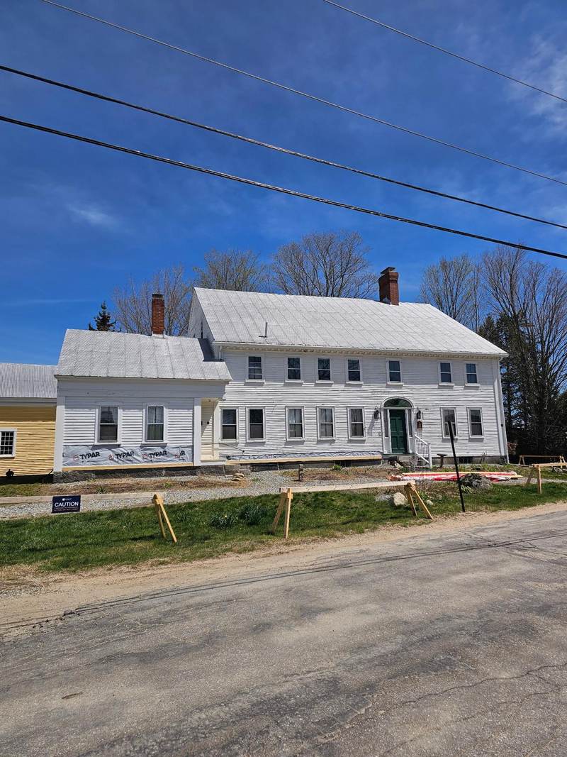The front of a white colonial-style house photographed on site.